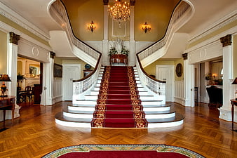 Grand foyer with red carpet staircase and chandelier