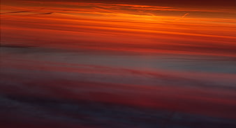 Vibrant Orange and Red Sunset Sky with Streaked Clouds