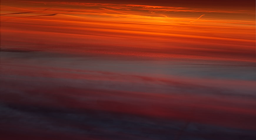 Vibrant Orange and Red Sunset Sky with Streaked Clouds