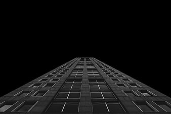 Low angle view of a modern skyscraper against a black background