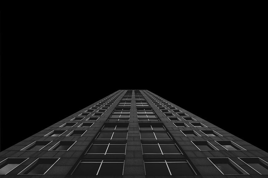 Low angle view of a modern skyscraper against a black background
