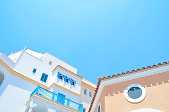 Mediterranean Architecture With Blue Shutters And Terracotta Roof Against Clear Sky