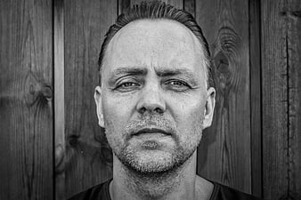 Black and white portrait of a mature man with short hair and stubble