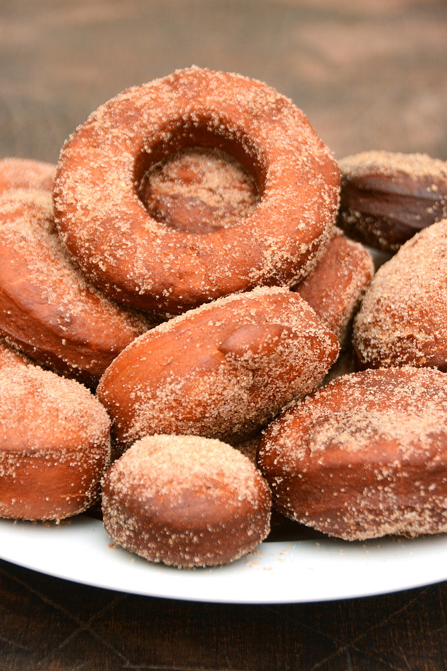 Pile of cinnamon sugar doughnuts on a white plate
