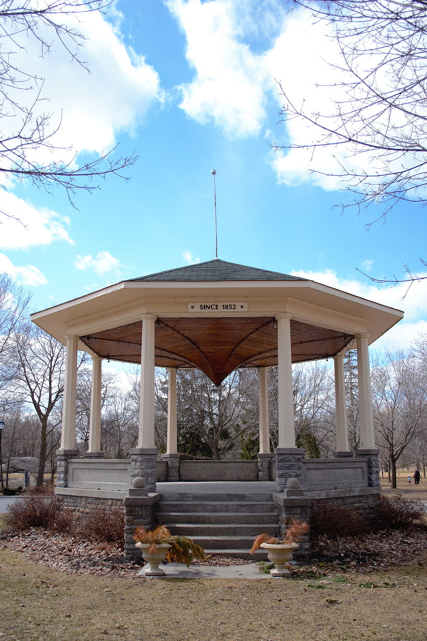 Historic white gazebo in park with blue sky