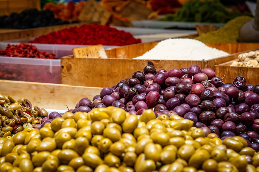 Fresh green and purple olives at a vibrant market stall