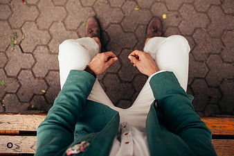 First-person view of man in green jacket sitting on bench