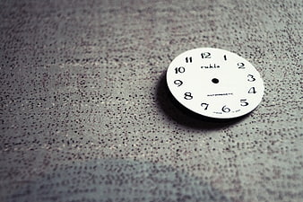 White Rühle Clock Dial on Textured Gray Surface