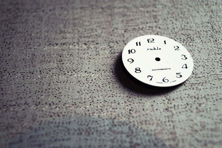 White Rühle Clock Dial on Textured Gray Surface