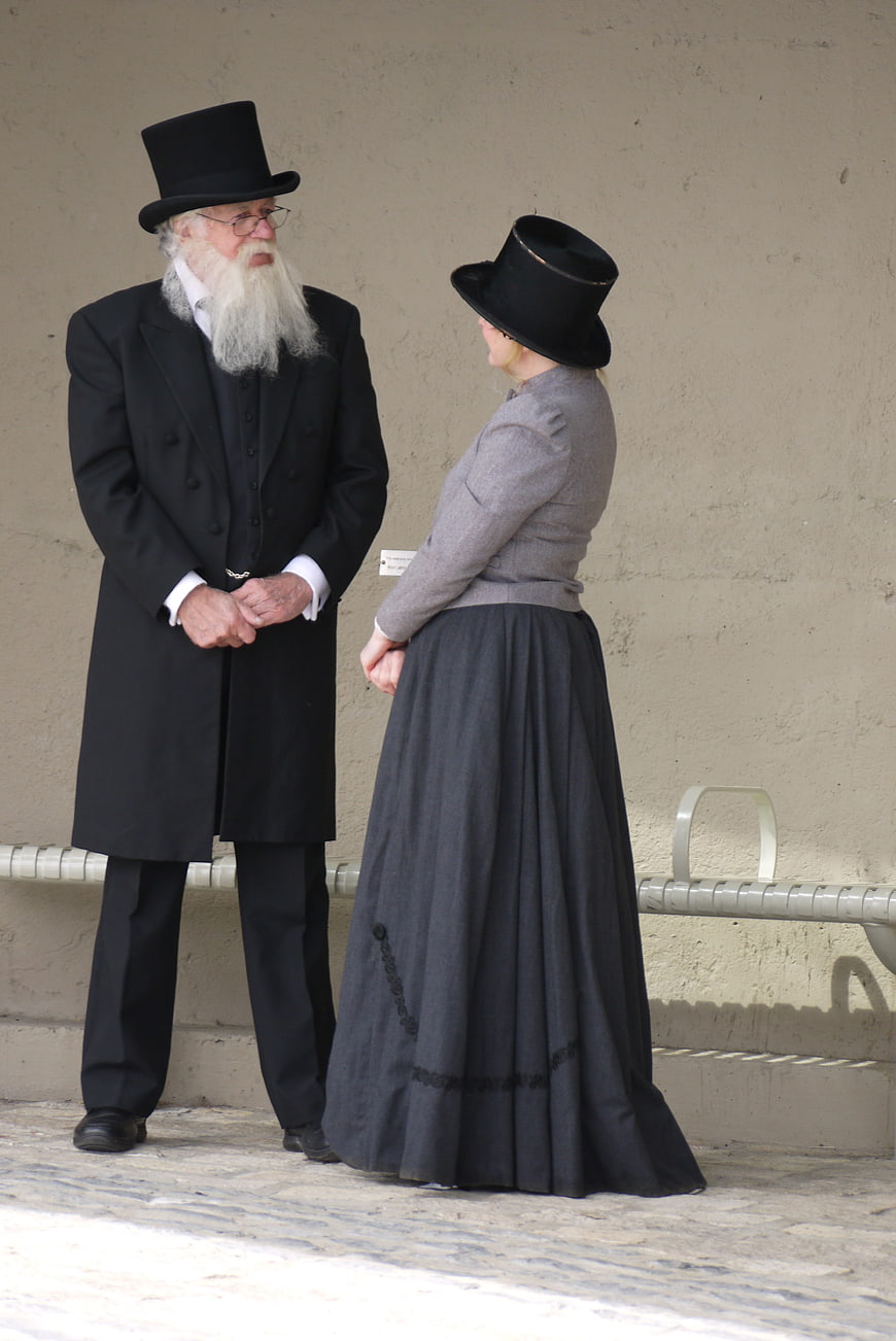 Senior couple in traditional Amish attire standing outdoors
