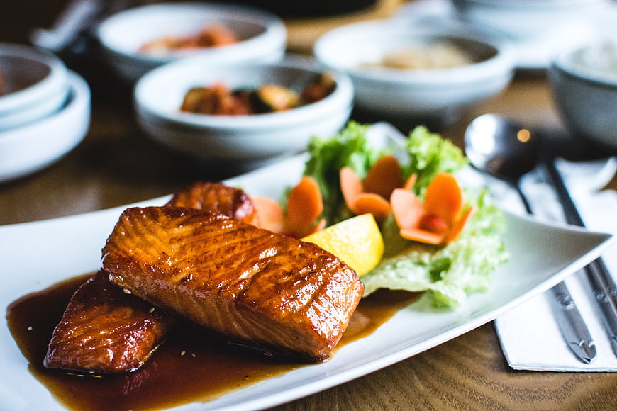 Glossy glazed salmon fillet with soy sauce and garnish