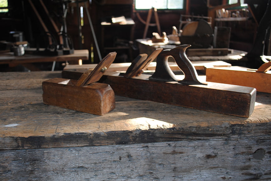 Vintage wooden hand planes on rustic workbench