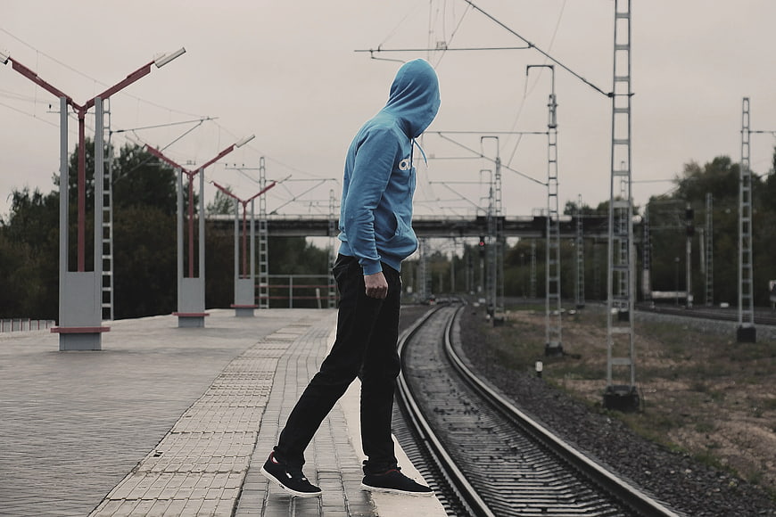 Man in Blue Hoodie Walking on Train Platform