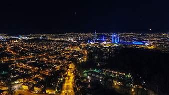 Aerial Night View of Cityscape with Illuminated Stadium and Residential Streets