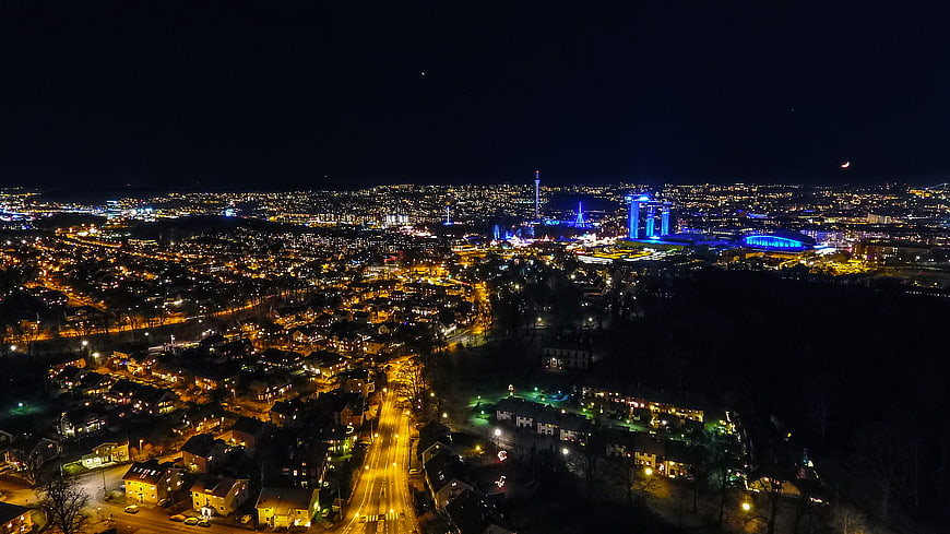 Aerial Night View of Cityscape with Illuminated Stadium and Residential Streets
