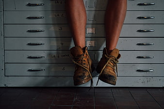 Work boots hanging in front of vintage gray drawers