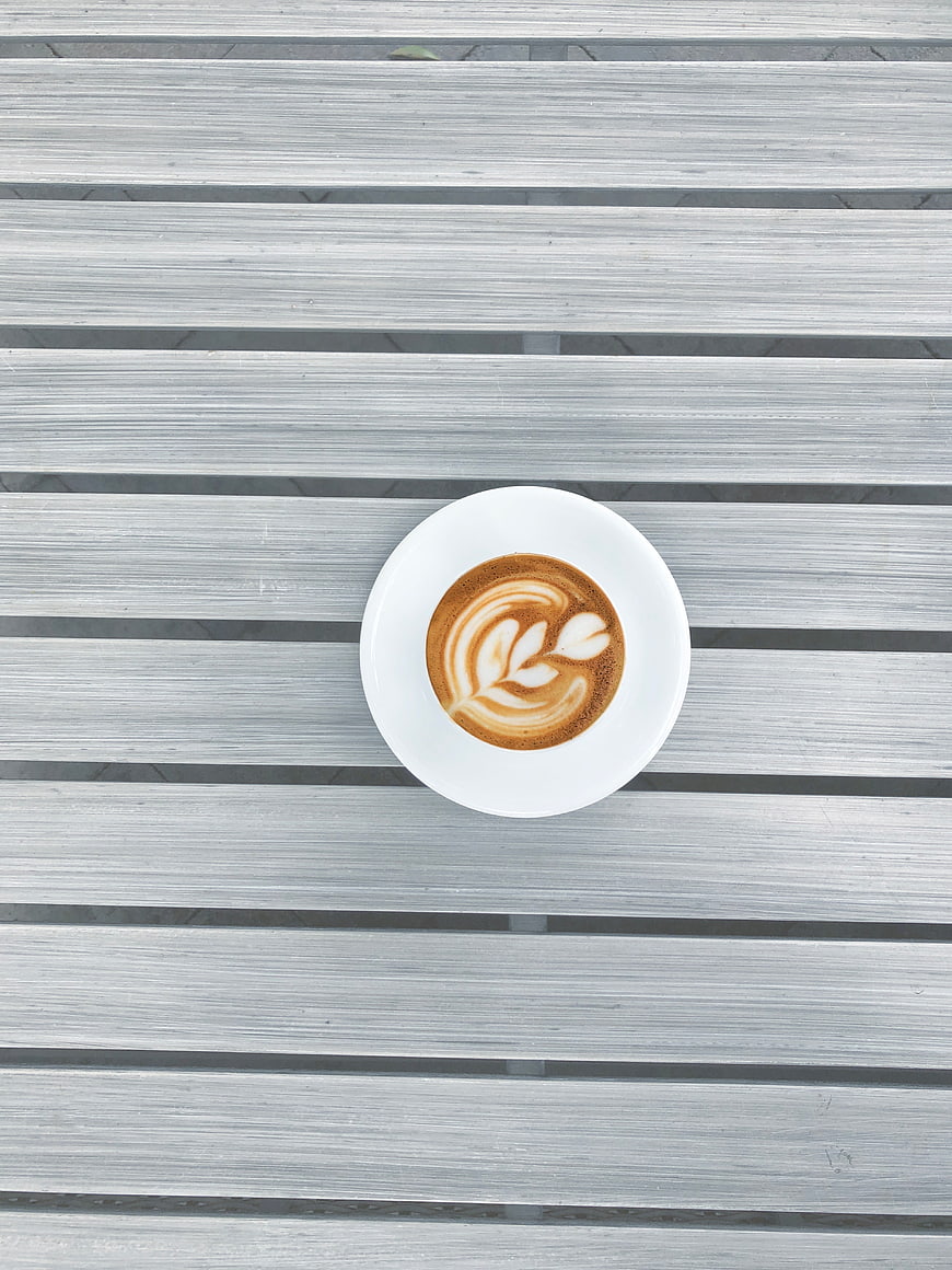Top view of latte art coffee on gray wooden table