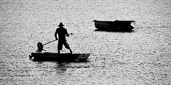 Silhouette of Fisherman in Boat on Rippled Water