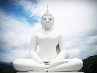 White Buddha Statue Meditating Against Blue Sky