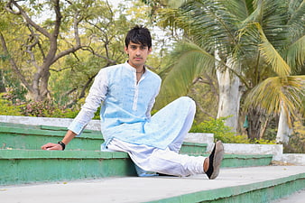 Young man in traditional Indian kurta sitting on steps