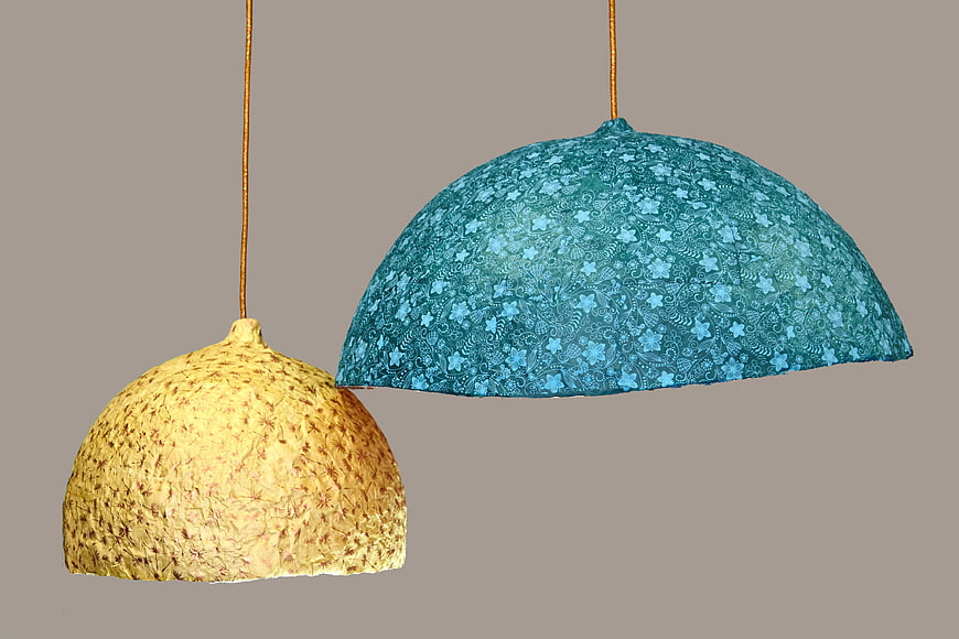 Two textured pendant lamps with floral patterns on gray background