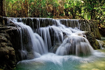 Serene Waterfall Flowing Over Rocks in Lush Forest
