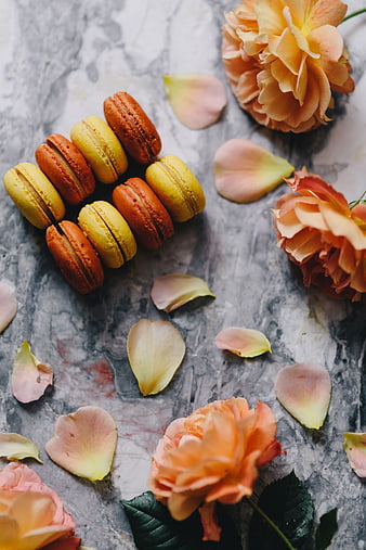 Colorful macarons and roses on marble background