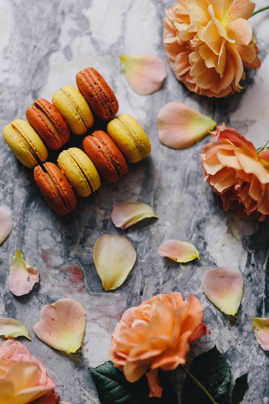 Colorful macarons and roses on marble background