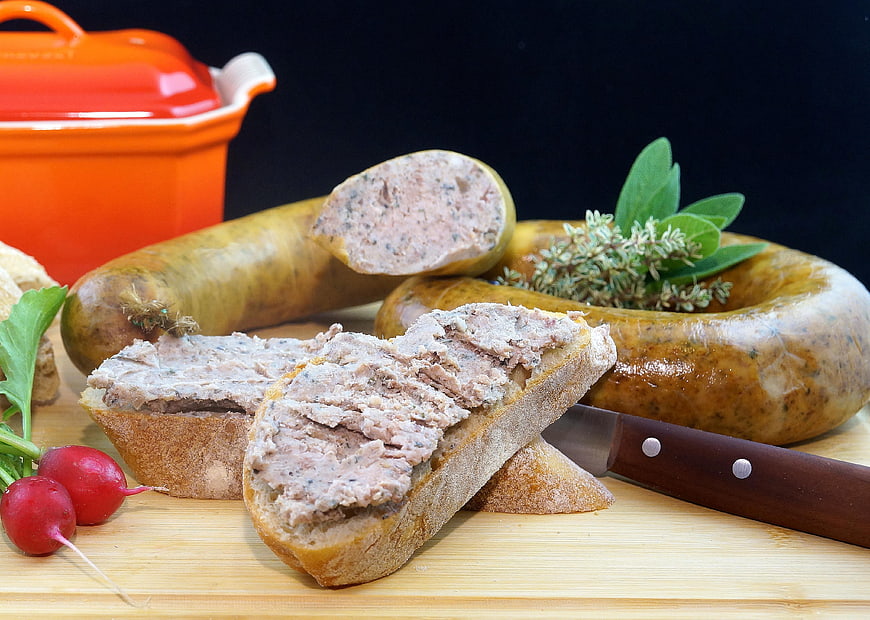 Sliced liverwurst on rustic bread with fresh radishes and herbs
