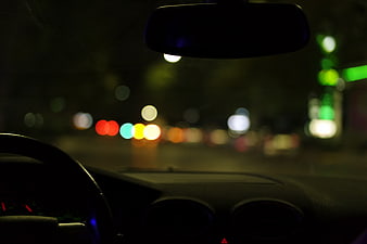 Night driving view from inside a car with bokeh lights