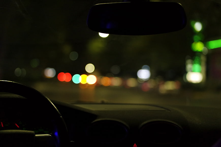 Night driving view from inside a car with bokeh lights