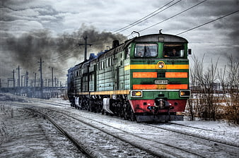 Green diesel locomotive on snowy railway tracks