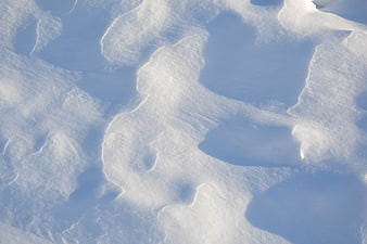 Close-up texture of snowdrifts with blue shadows