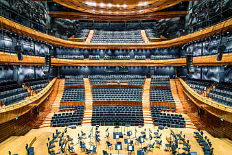Empty modern concert hall with wooden stage and orchestra seating