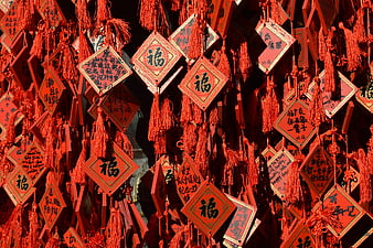 Red Chinese prayer plaques with calligraphy hanging in temple