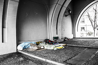 Homeless sleeping bags under stone arches in Madrid