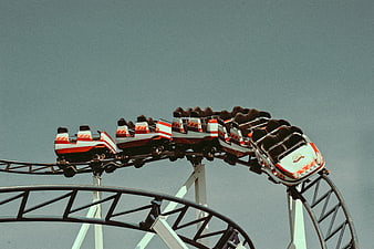 Empty Roller Coaster Cars on Track Against Blue Sky