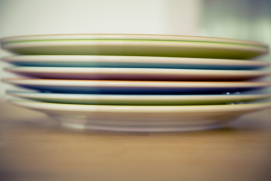 Stack of colorful ceramic plates on wooden table