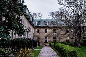 Historic stone building with brick pathway and garden
