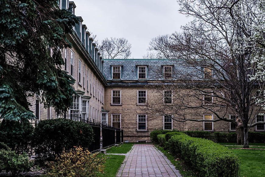 Historic stone building with brick pathway and garden