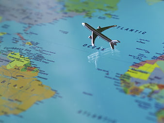 Miniature Airplane on World Map Over Atlantic Ocean