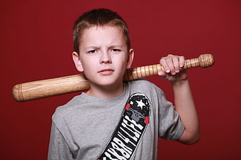 Angry Boy Holding Wooden Baseball Bat on Red Background