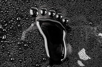Black and white macro of wet footprint with water droplets