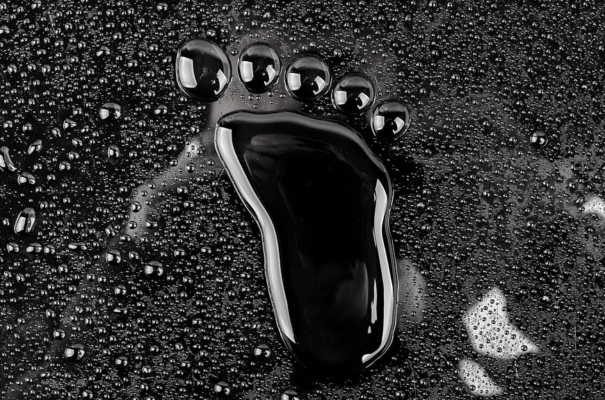 Black and white macro of wet footprint with water droplets