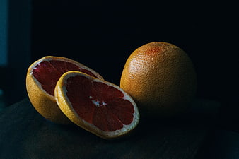 Dark moody still life of blood oranges on wooden table