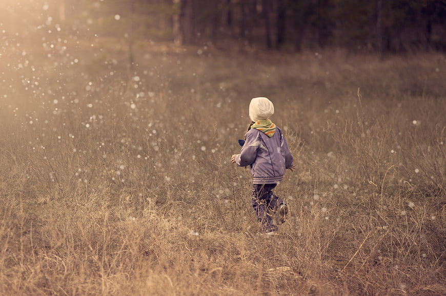 Child running through field in winter snow