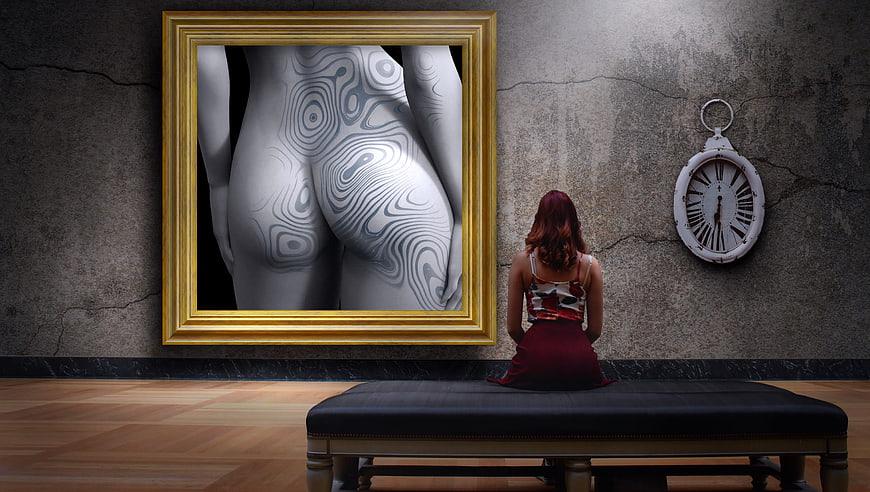 Woman sitting on bench viewing surreal body art in gold frame