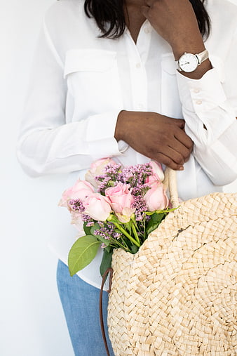 Woman holding pink roses and straw basket