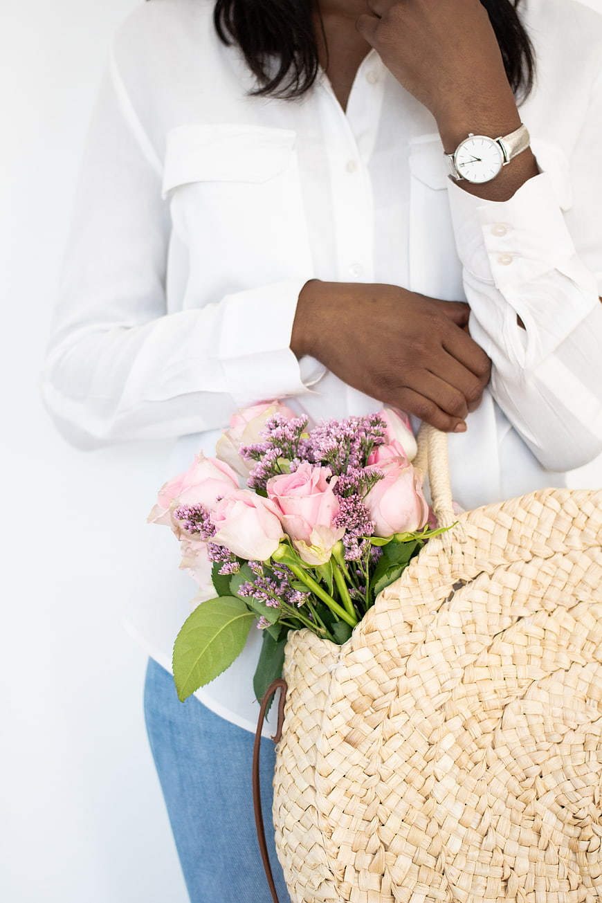 Woman holding pink roses and straw basket