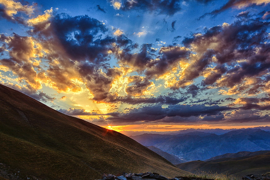 Dramatic Sunset Over Mountain Ranges With Golden Clouds